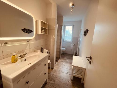 博恩Ferienwohnung van der Holm的白色的浴室设有水槽和镜子