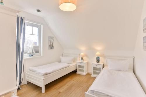 博恩Ferienwohnung Harmonie in Born的白色的客房设有两张床和窗户。