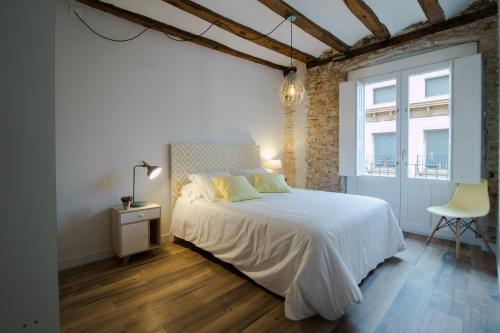 萨拉戈萨Apartamentos Almada的卧室配有白色的床和椅子