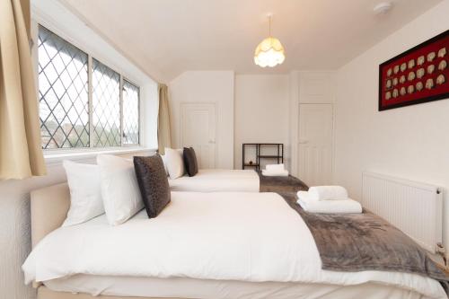 Baguley3BR Cottage in the Heart of Cheadle的一间卧室设有两张床和窗户。