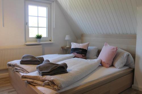 博恩Ferienhaus Ilva in Born的一间卧室配有带毛巾的床和窗户。