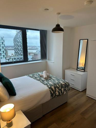利物浦Stunning City View Apartment by Central Stay的一间卧室设有一张床和大窗户