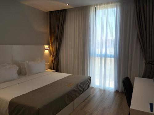 地拉那Metro Hotel Terminal的酒店客房设有一张床和一个大窗户