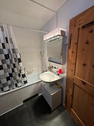 芙露姆赛山Flumserberg的浴室配有盥洗盆和浴缸。