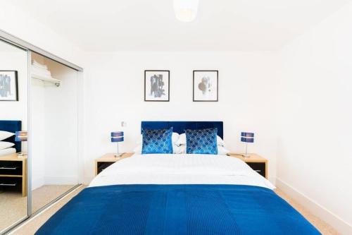 伯明翰Duplex 2 Bedroom Apartment In City Nites - Near Arena - 2 Bathroom - City Centre的卧室配有蓝色和白色的床和镜子
