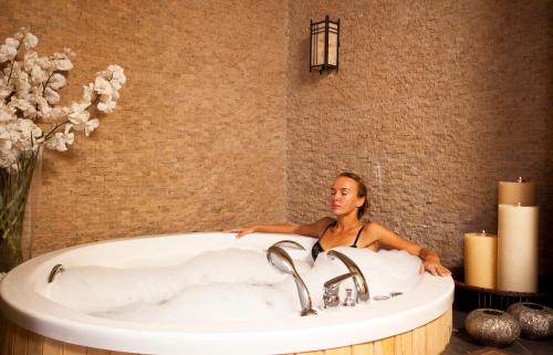 贝莱克Limak Atlantis Deluxe Hotel Belek的坐在浴室浴缸里的女人