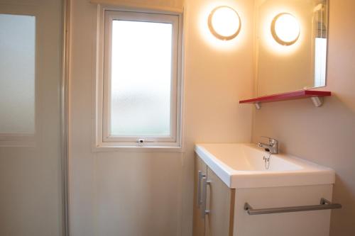 索恩河畔克雷什CAMPING LA CLE DE SAONE的一间带水槽和窗户的浴室