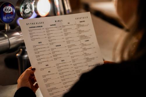 厄斯特松德克拉丽奥格兰德厄斯特松德酒店的一个人拿着一张纸,上面有菜单