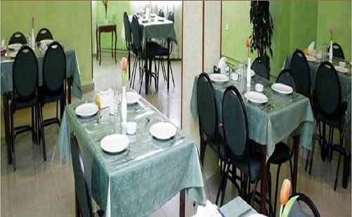 安曼Conord Hotel - "Amman's Heart"的两幅带桌椅的用餐室的照片