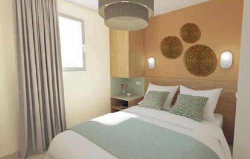 耶尔Résidence Prestige Odalys Le Riviera的一间卧室设有一张大床和一个窗户。