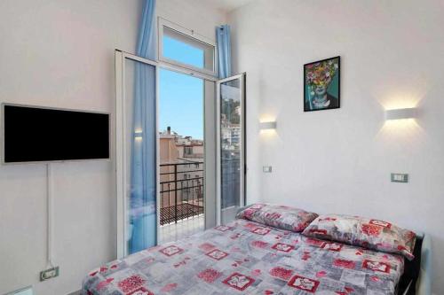 圣雷莫Frida apartments的一间卧室设有一张床和一个大窗户