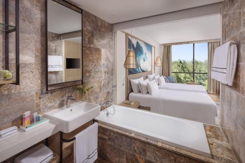 岘港Melia Danang Beach Resort的带浴缸、水槽和床的浴室