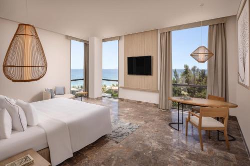 岘港Melia Danang Beach Resort的酒店客房设有床、桌子和电视。