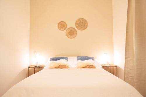 蒂沃利La Bifora的卧室配有带两盏灯的白色床