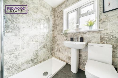 奥尔顿2 Bed 1 Bath House, Perfect for Corporate, Contractors & Families x2 FREE Parking, Garden, Netflix By REDWOOD STAYS的浴室配有盥洗盆、卫生间和浴缸。