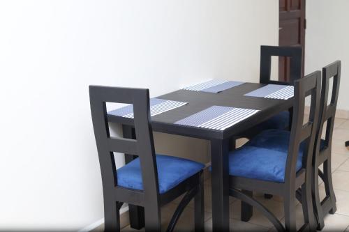 坎帕拉pettan Appartment的一张带两把椅子的黑桌、一张桌子和一张桌子及椅子。