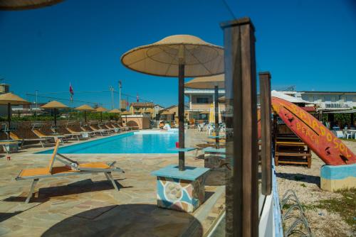 利多迪费尔莫Residence Baiadosol的游泳池旁设有椅子和遮阳伞