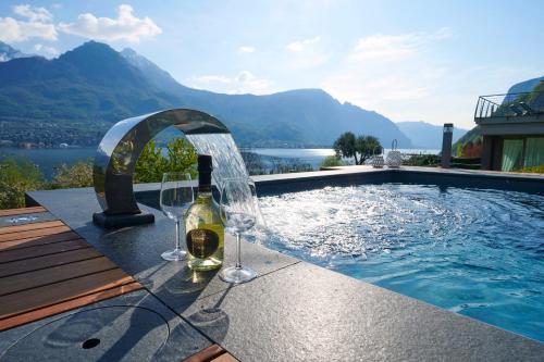 奥利维托拉里奥Villa Vittoria with private seasonal heated pool & shared sauna - Bellagio Village Residence的游泳池旁的一瓶葡萄酒和玻璃杯