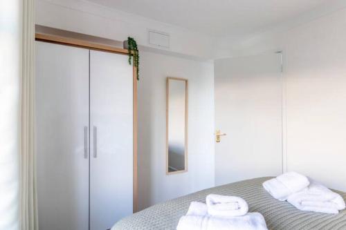 伯恩茅斯Large Sea View 2 bedroom Sleeps 6 - Free Parking的白色卧室,配有带毛巾的床