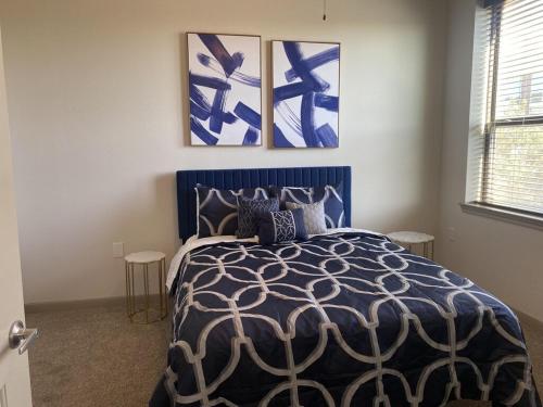 休斯顿Luxe Getaway Astros NRG Galleria的一间卧室配有一张蓝色的床,墙上挂有三幅画作
