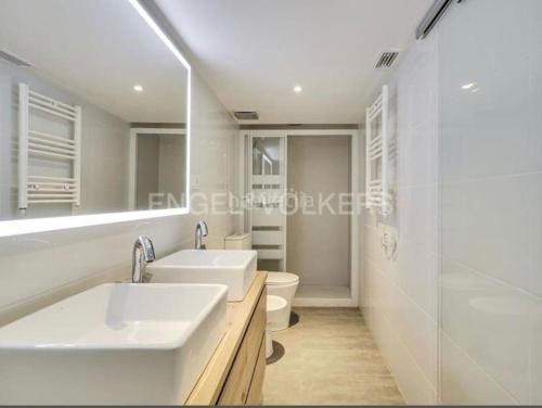 巴达洛纳apartamento exclusivo muy cerca ciudad Barcelona的白色的浴室设有2个盥洗盆和1个卫生间。
