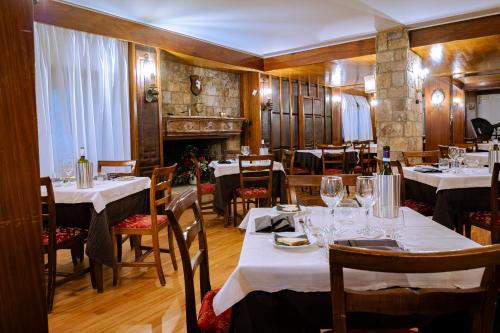 佩斯卡塞罗利Hotel Corona & Spa的餐厅配有桌椅和白色桌布