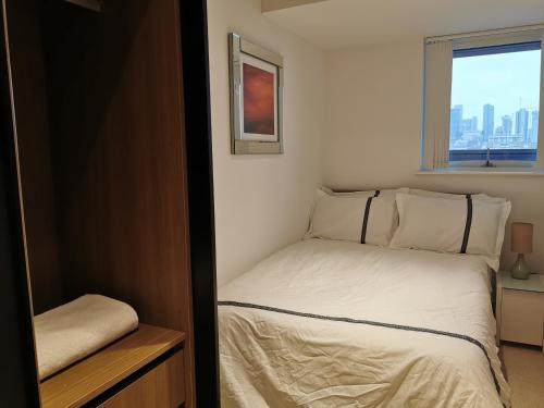 伦敦Homestay Room in Apartment with Stunning Thames River View的一间小卧室,配有床和窗户
