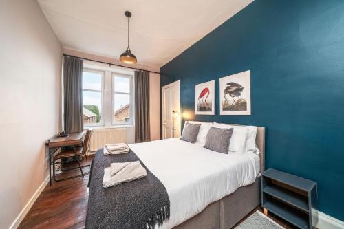 布莱尔高里Central Apartment - Industrial的一间卧室设有一张大床和蓝色的墙壁