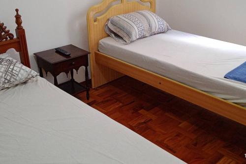 波苏斯-迪卡尔达斯Excelente Apartamento em Área Nobre的一间卧室设有两张单人床和一个床头柜。