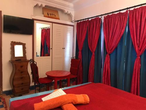 索维拉瑞德格诺奥酒店的一间卧室配有红色和蓝色的窗帘和桌子