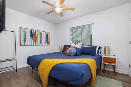 伯明翰Vulcan’s Hideout / Colorful C2的一间卧室配有一张大蓝色的床和吊扇