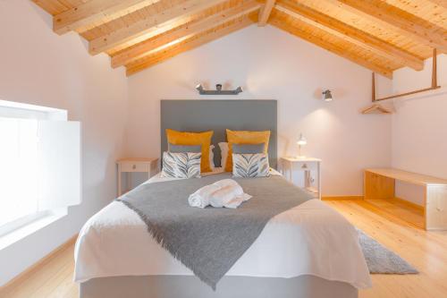 奥比多斯Retiro do Castelo的一间卧室设有一张带木制天花板的大床。