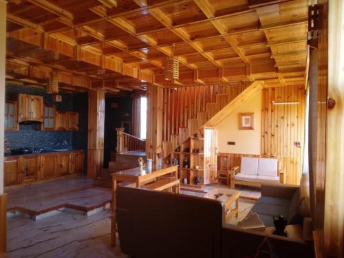 西姆拉Forest Walk Cottage by Livingstone的一间带木墙和楼梯的客厅