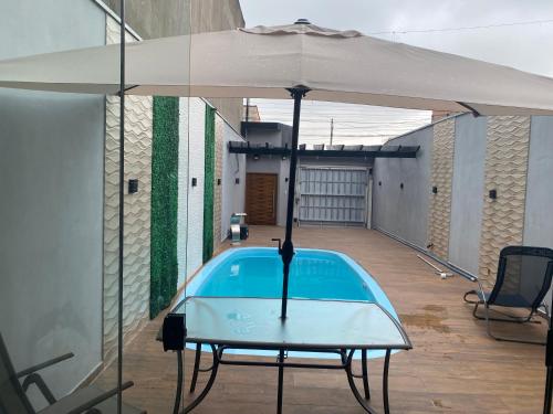 瓜鲁柳斯Casa premium two brothers的庭院内一个带遮阳伞的游泳池