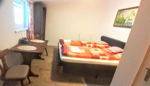 拉肯霍夫Villa Fortuna Budget的一间卧室配有一张床、一张桌子和一张桌子。