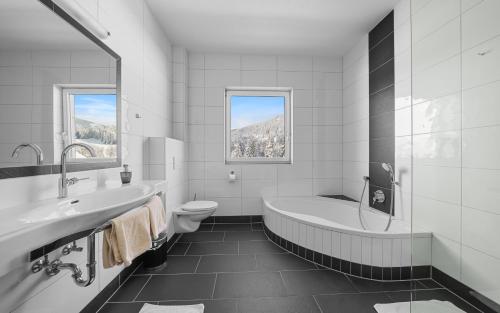 拉姆绍达赫斯坦福森施耐纳豪华公寓酒店的带浴缸、卫生间和盥洗盆的浴室