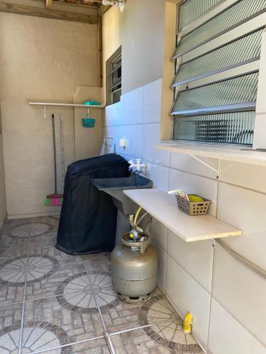 弗洛里亚诺波利斯Apartamento encantador cachoeira的客房铺有瓷砖地板,设有带桌子的厨房。
