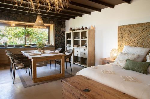 蒂亚斯La Finquita的一间带桌子和床的卧室以及一间用餐室