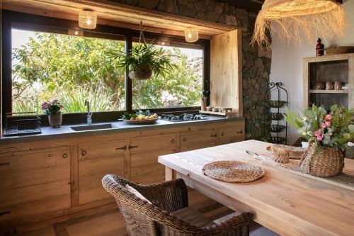 蒂亚斯La Finquita的厨房配有木桌和大窗户。