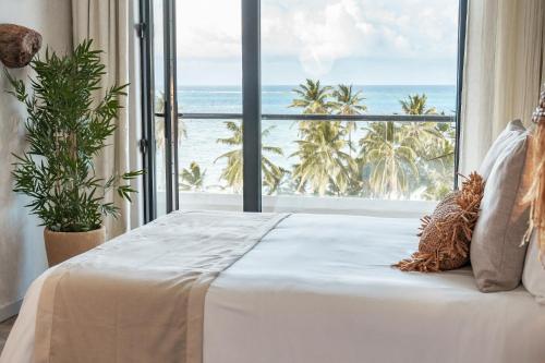 圣安德烈斯Nattivo Collection Hotel的一间卧室设有一张床,享有海景