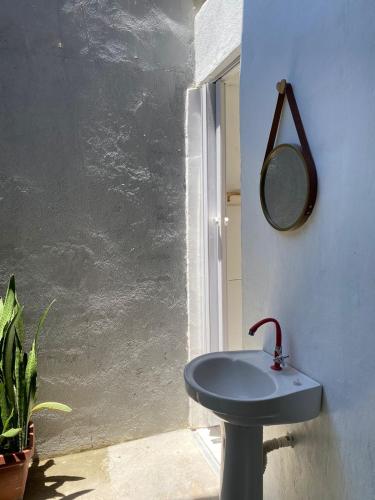 阿拉亚尔达茹达Hostel Aconchego do Arraial的浴室设有蓝色水槽和镜子