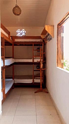 阿拉亚尔达茹达Hostel Aconchego do Arraial的客房设有三张双层床和一扇窗户。