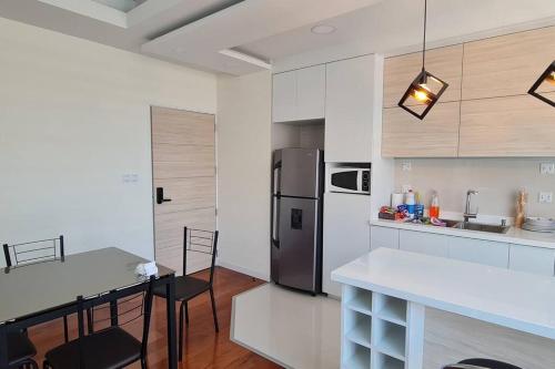 拉巴斯departamento de 2 dormitorios的厨房配有冰箱和桌椅