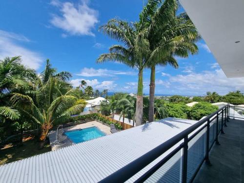 圣皮埃尔Villa Fleur de Coco - 8p. - piscine privée - haut standing的阳台设有游泳池和棕榈树