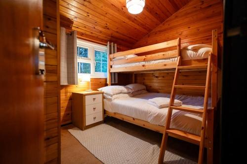 FfestiniogRural Log Cabin Retreat near Coed y Brenin by Seren Short Stays的小木屋内一间卧室配有双层床