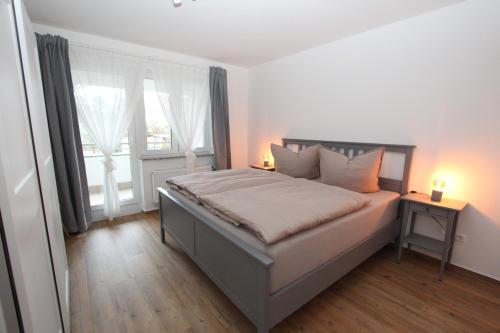 巴特萨罗皮斯库夫Ferienwohnung Bad Saarow, Seestr. 2的一间卧室配有一张带两盏灯的床和一扇窗户。