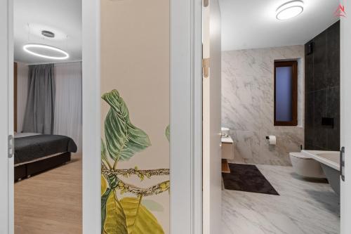 波亚纳布拉索夫Grand Chalet Holiday Apartment Poiana Brasov的客房设有带卧室的浴室。