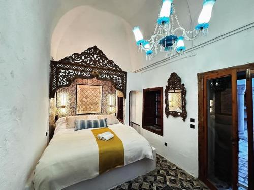 西迪·布·赛义德Suite Noor B&B Pool SidiBouSaid的一间卧室配有一张床和一个吊灯