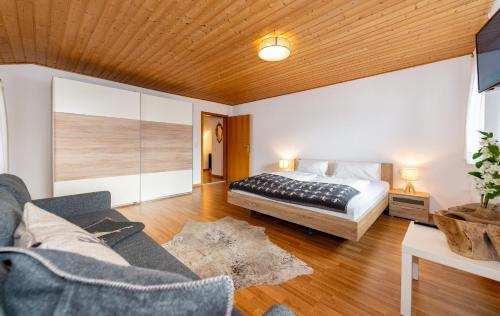 埃尔瓦尔德Alpen Appartements Marlene的一间卧室配有一张床和一张沙发