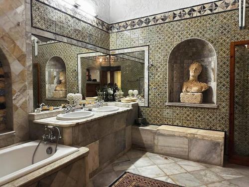 西迪·布·赛义德Suite Noor B&B Pool SidiBouSaid的一间带两个盥洗盆、浴缸和雕像的浴室